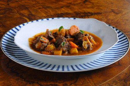 Slow-cooked beef cheek goulash plated and served by an Algarve chef, prepared for premium food delivery