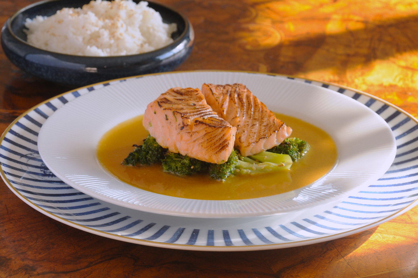 Miso glazed salmon with roasted broccoli and wafu dressing on a striped plate, chef-prepared frozen ready meal Algarve